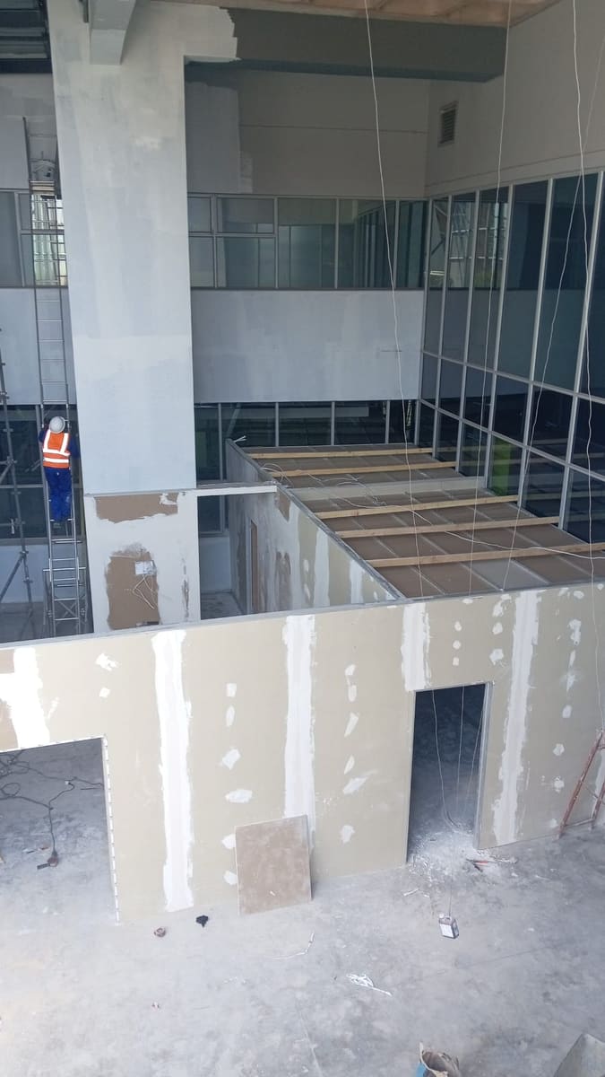 The interior shell at plasterboard stage, openings framed through the double-height space.