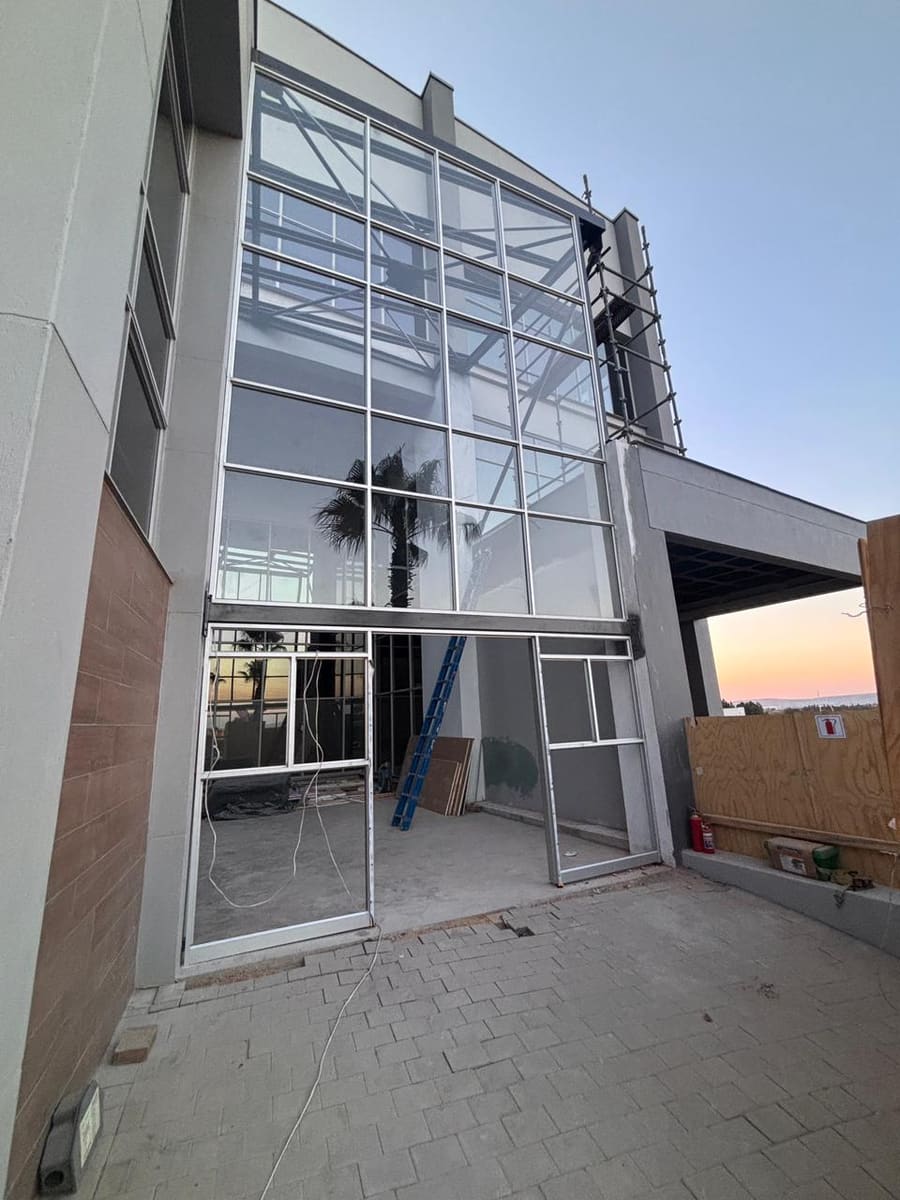The double-height glazed facade with its framing in place.