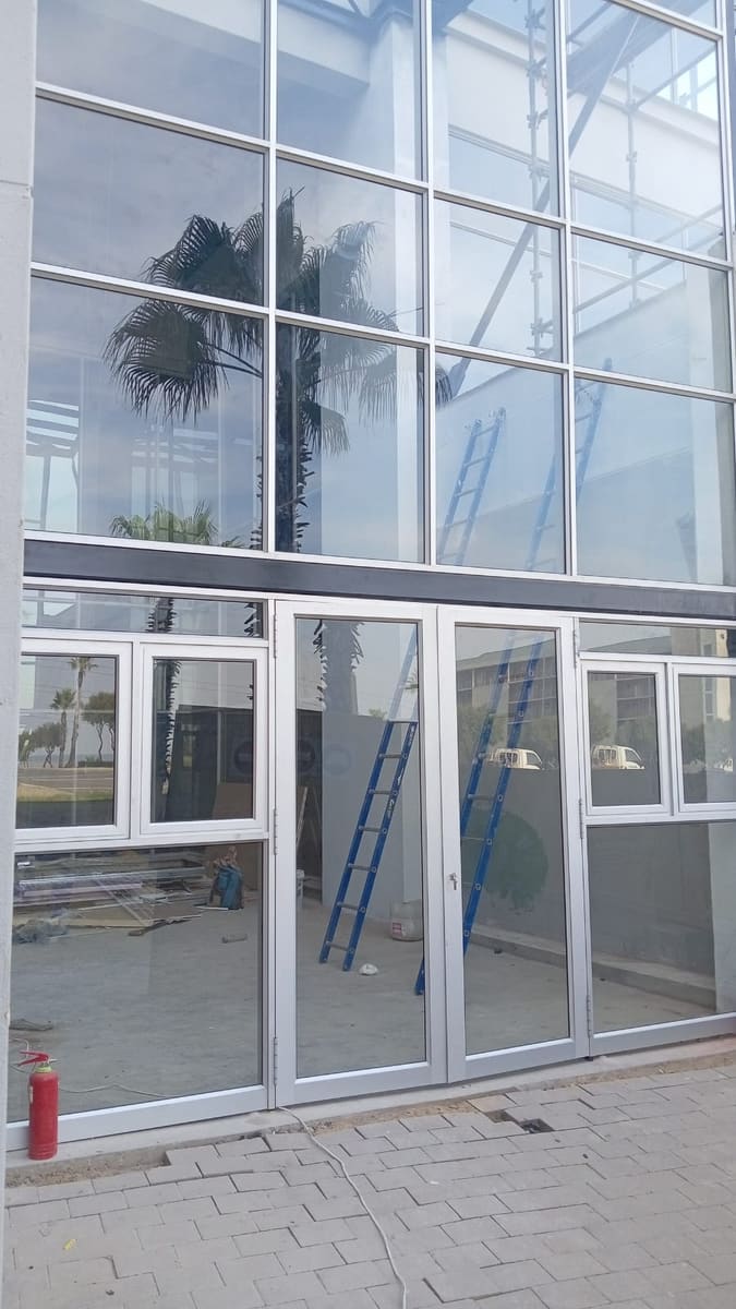 The glazed entrance screen installed, seen from the forecourt.