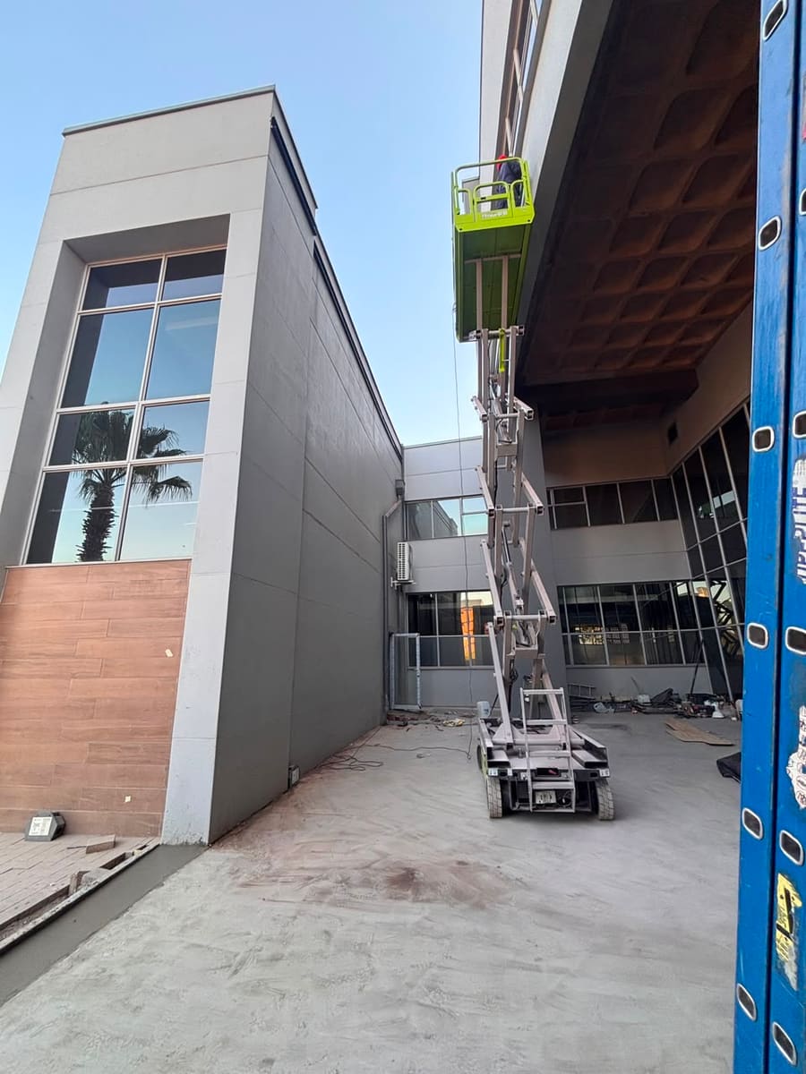 The canopy and upper facade under construction, seen along the approach.